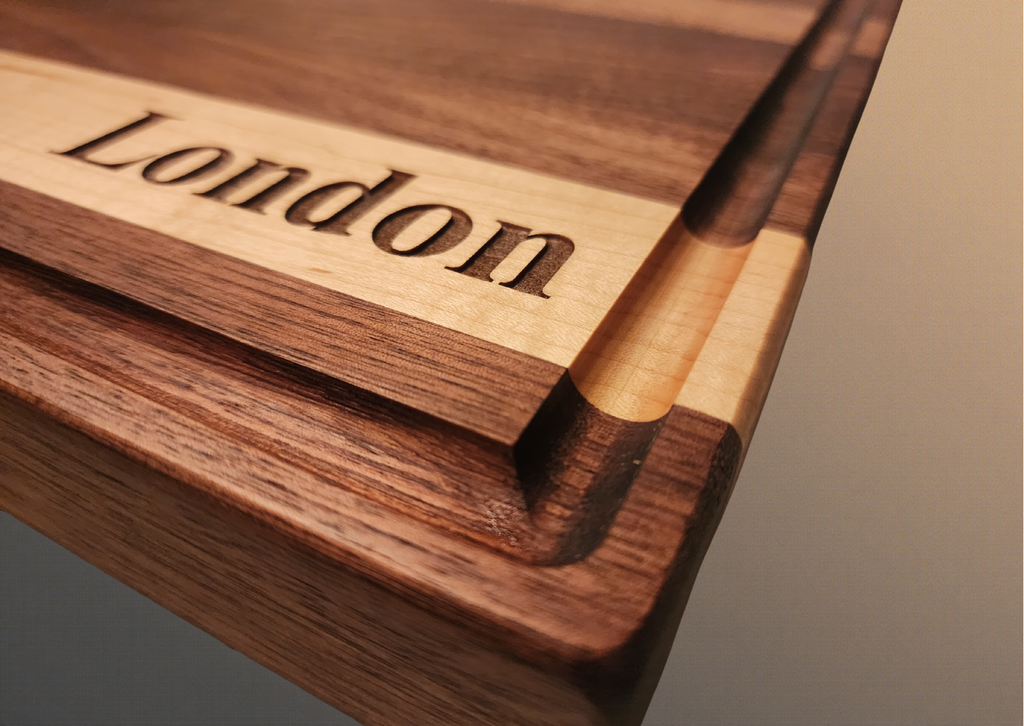 Walnut cutting board with accent piece on lower that is maple with London laser engraved